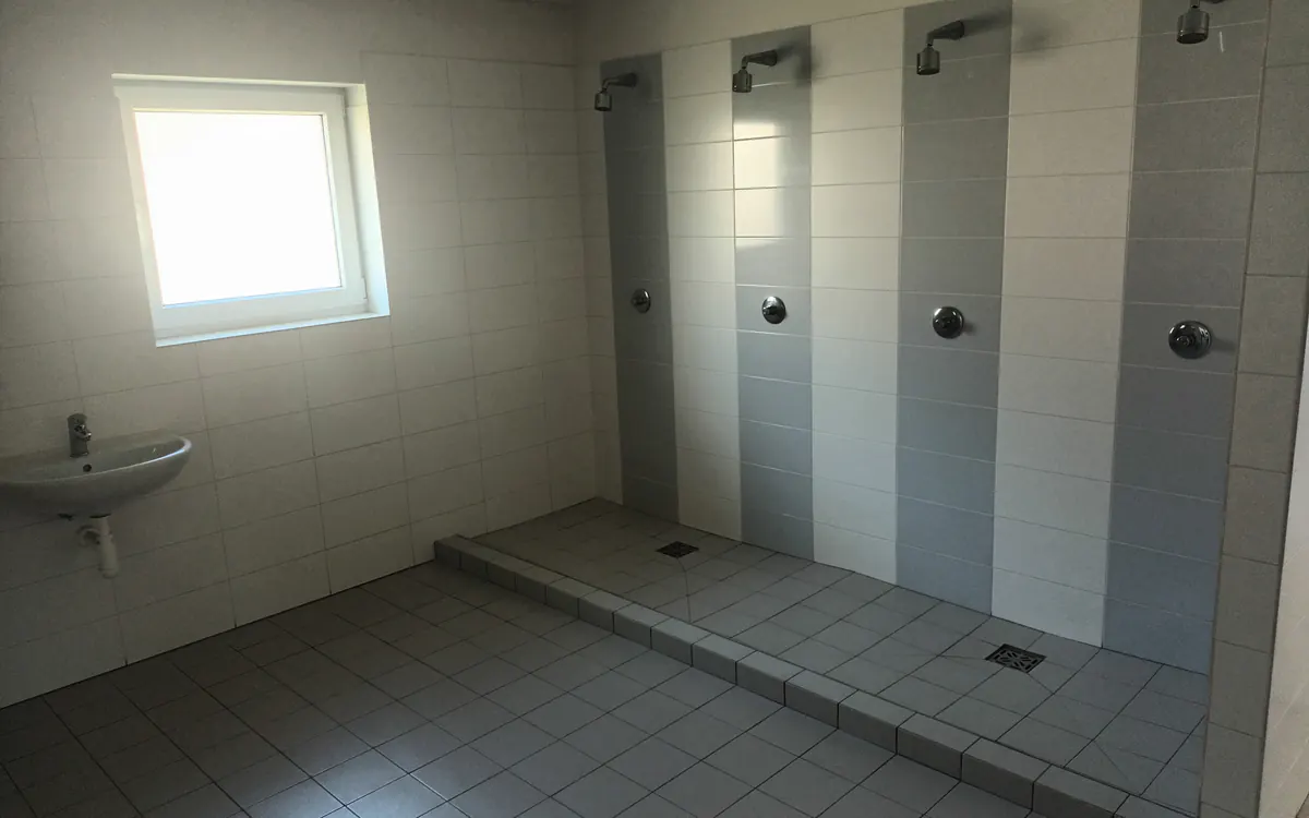 Společné sprchy v zázemí sportovního areálu